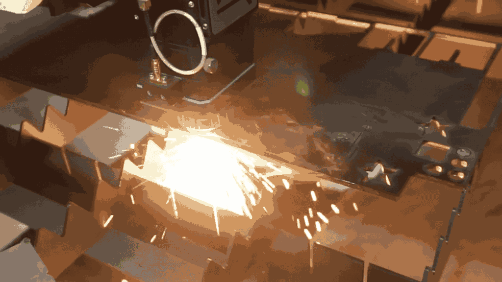 Detail mesin CNC laser cutting yang memotong plat besi dengan efek percikan api di permukaan plat