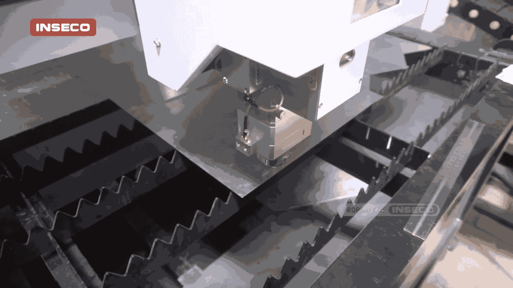 Mesin CNC Fiber Laser Cutting sedang memotong plat besi dengan presisi tinggi di workshop, menunjukkan proses pemotongan dengan ketelitian pada motif zig-zag