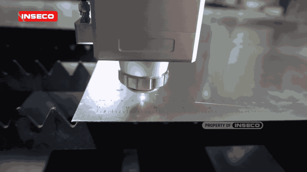 Proses pemotongan plat besi menggunakan mesin fiber laser CNC dengan fokus pada kepala laser dan presisi pengukuran untuk hasil pemotongan yang sangat akurat